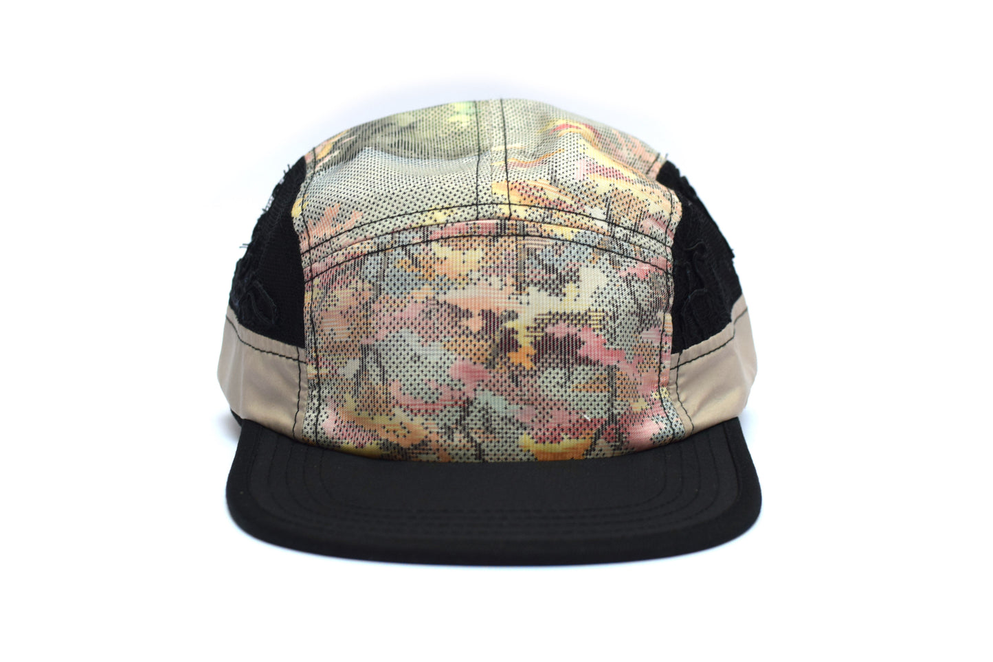 Multicolored camouflage cap with black mesh back on a white background